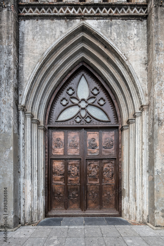 Brass door with bas reliefs captured at St Joseph's cathedral in the old quarter of Hanoi, Vietnam