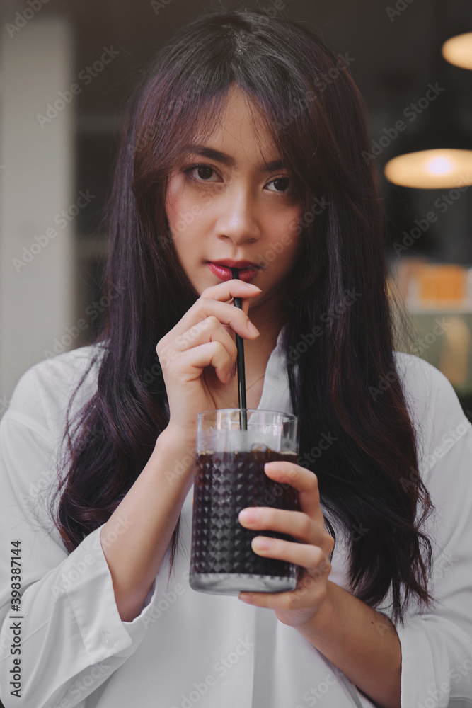 young asian woman drinking iced coffee