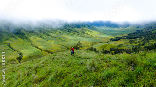 Bromo Indonesia December 10, 2020: Young man riding Gravel bike riding on a green grass field with gravel bicycles concept in Bromo  © Ara Creative