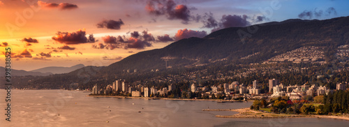 Fototapeta Naklejka Na Ścianę i Meble -  West Vancouver, British Columbia, Canada. Aerial Panoramic View of a modern cityscape on the Pacific Ocean Coast during an Autumn sunny and cloudy sunset.
