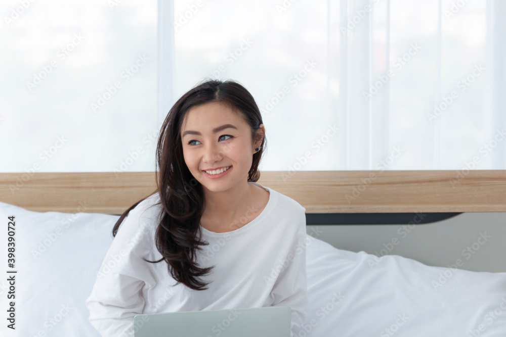 Happy casual beautiful woman working on a laptop sitting on the bed at home. Teen girl school student watch video online webinar learning on laptop sit on bed, distance e-learning course. Happy casual beautiful woman working on a laptop sitting on the bed at home. Teen girl school student watch video online webinar learning on laptop sit on bed, distance e-learning course.