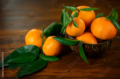 Fresh Tangerines With Leaves In Bowl On Wooden Table.