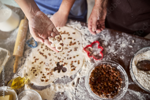 Family activity of making gingerbread men with dash of raisins