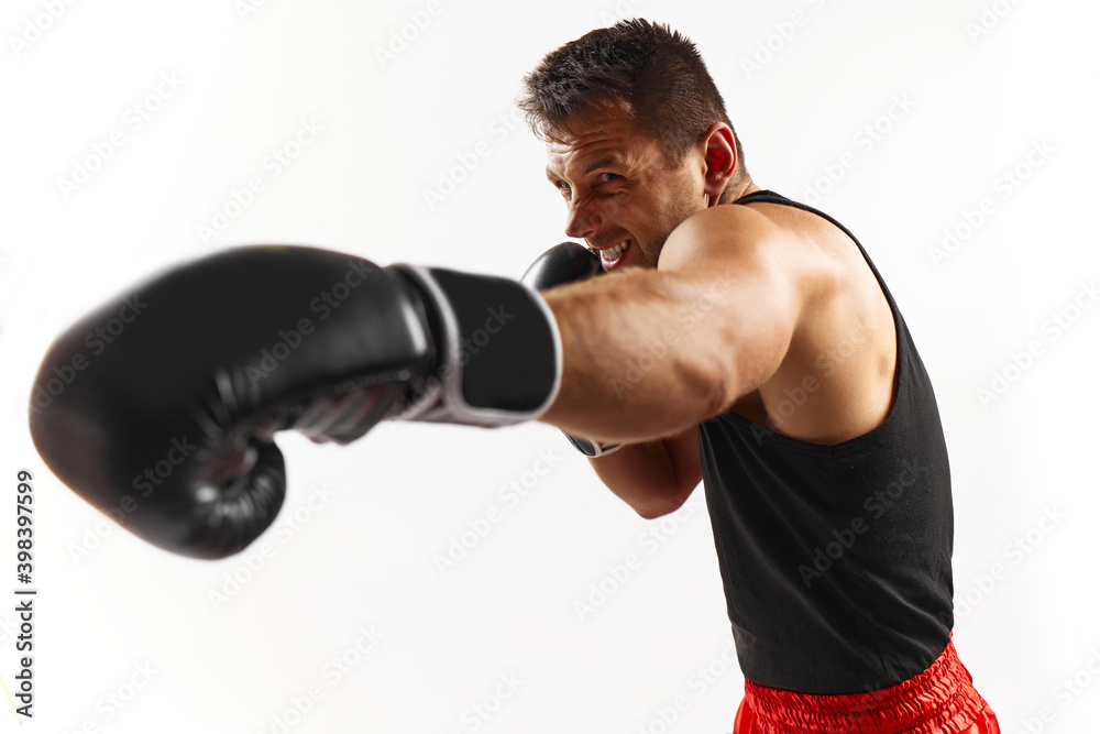 sporty man in black boxing gloves hitting at camera isolated on white background.