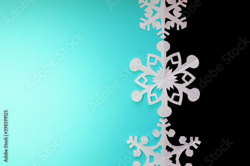 Paper snowflakes on turquoise background, top view