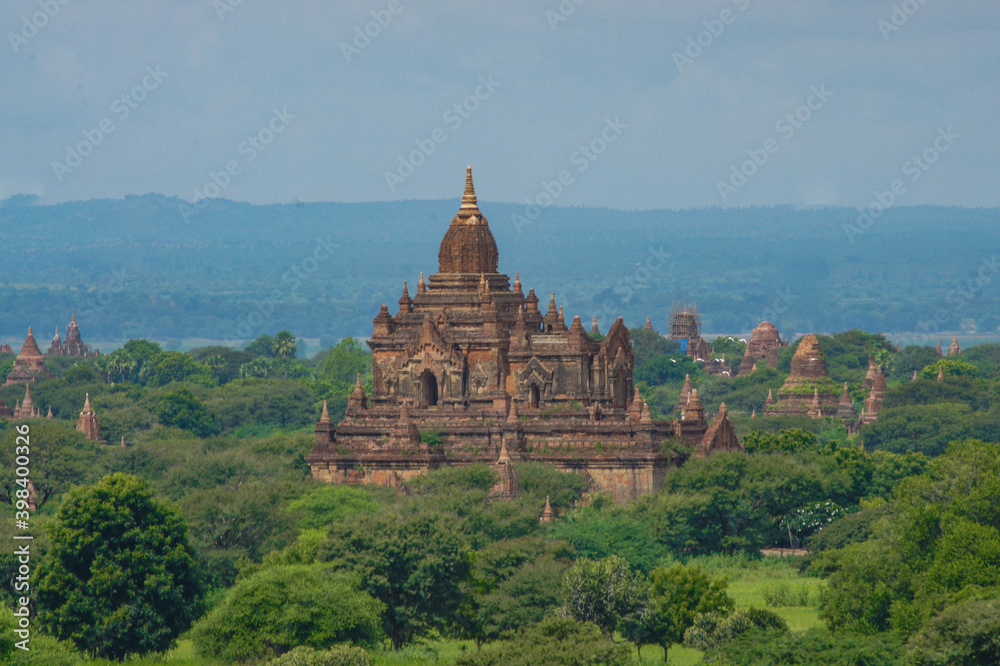 a large building with a tower surrounded by trees and hills a large building with a tower surrounded by trees and hills