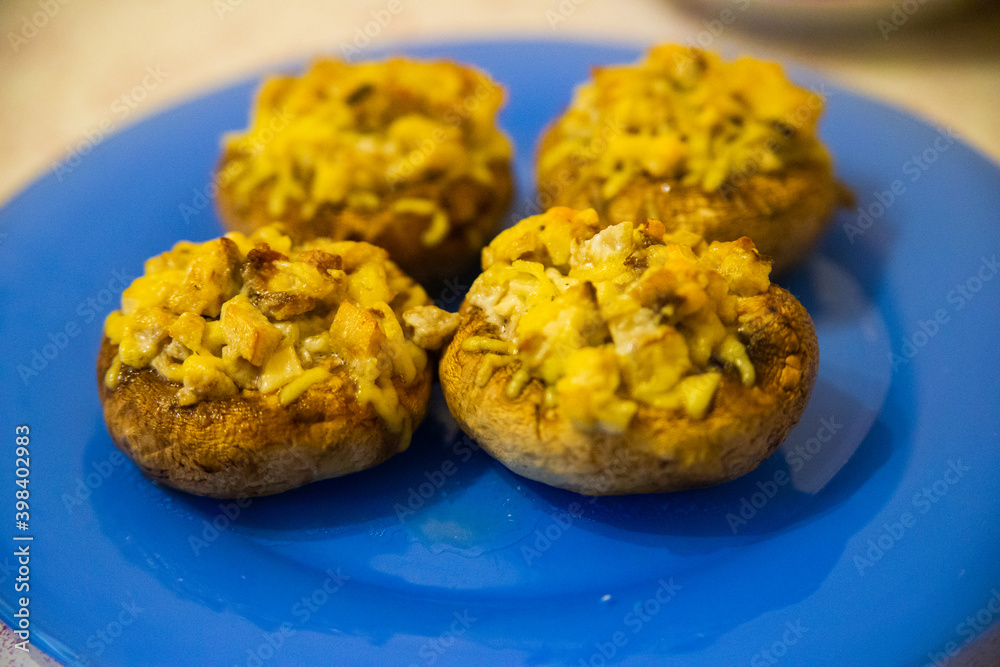Grilled mushrooms stuffed with cheese on blue plate Grilled mushrooms stuffed with cheese on blue plate