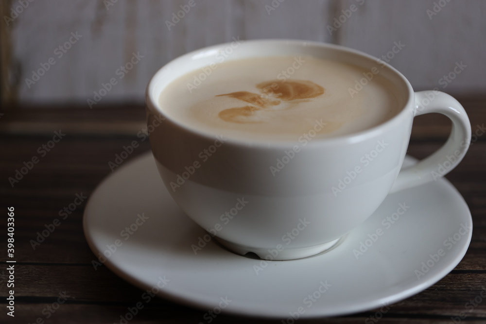 coffee in white cup with saucer on wooden table with wooden bottom coffee in white cup with saucer on wooden table with wooden bottom