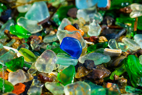 Natural background with sea glass close-up on sand.