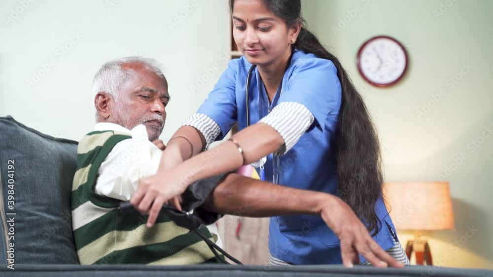 Nurse of doctor busy in setting up BP or blood pressure medical equipment to senior man at home of check up at home - concept of routine home help check. Nurse of doctor busy in setting up BP or blood pressure medical equipment to senior man at home of check up at home - concept of routine home help check.