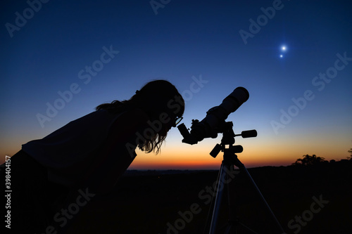Tableau sur toile Woman looking at night sky with amateur astronomical telescope.
