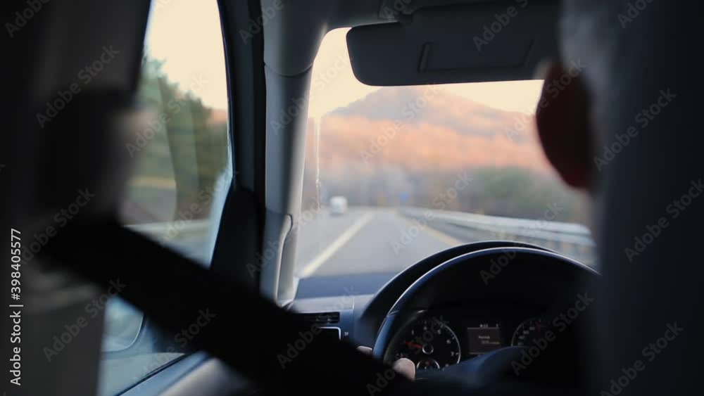 A man drives a car. Rear view of the empty road ahead. Close-up of dashboard and steering wheel A man drives a car. Rear view of the empty road ahead. Close-up of dashboard and steering wheel