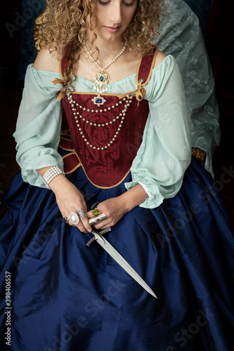A young renaissance woman holding a weapon