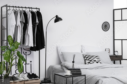 Interior of stylish bedroom with clothes rack © Pixel-Shot