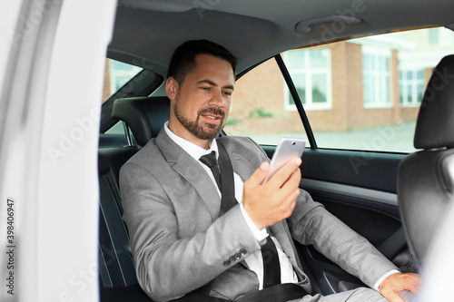 Successful businessman with mobile phone in modern car © Pixel-Shot