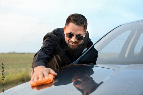 Handsome man washing his ca...