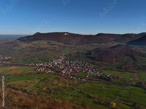 Aerial panoramic view of small village Brucken, part of Lenningen, Baden-Wuerttemberg, Germany, located in valley on the foothills of low mountain range Swabian Alb in autumn season on sunny day. photo