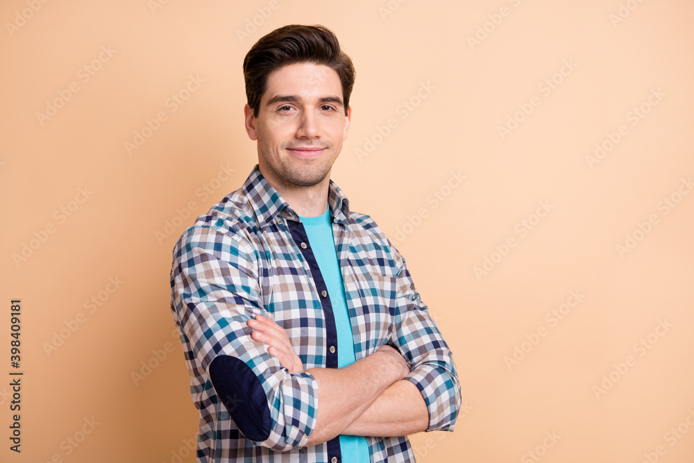 Profile side view portrait of nice cheery content guy folded arms isolated over beige pastel color background Profile side view portrait of nice cheery content guy folded arms isolated over beige pastel color background