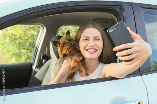 Woman with cute dog taking selfie in car © Pixel-Shot