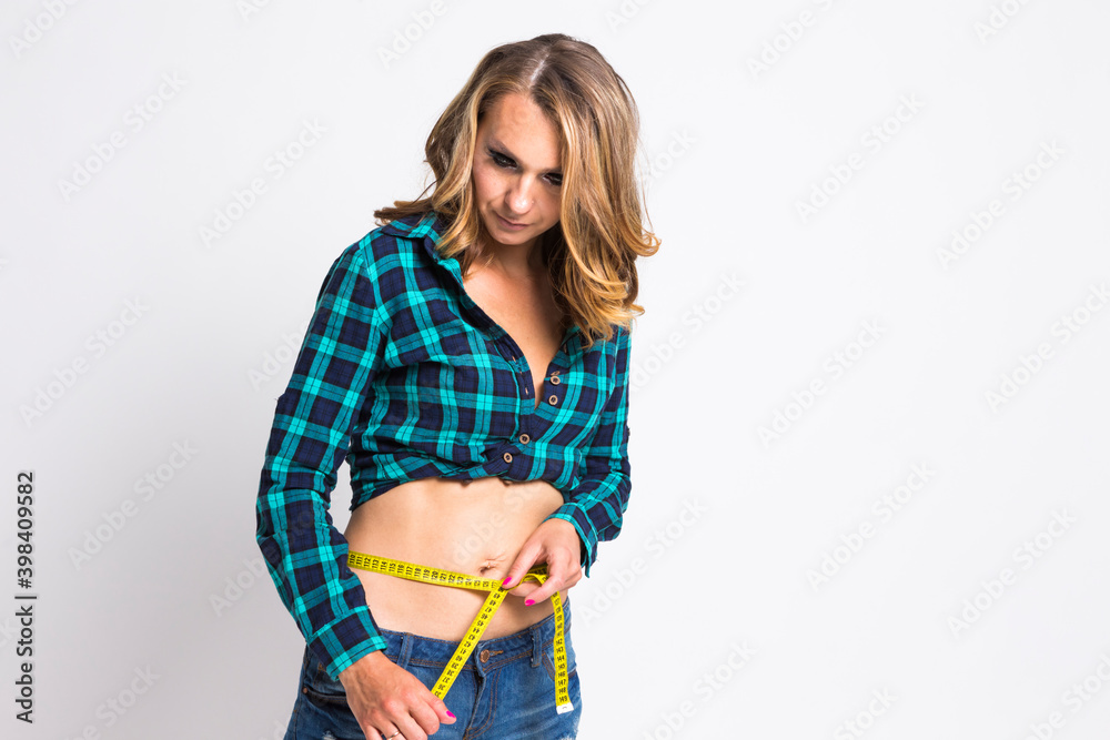 Annoyed and Concentrated Woman Using Yellow Tape Measure With Lifted Hand Against White Annoyed and Concentrated Woman Using Yellow Tape Measure With Lifted Hand Against White