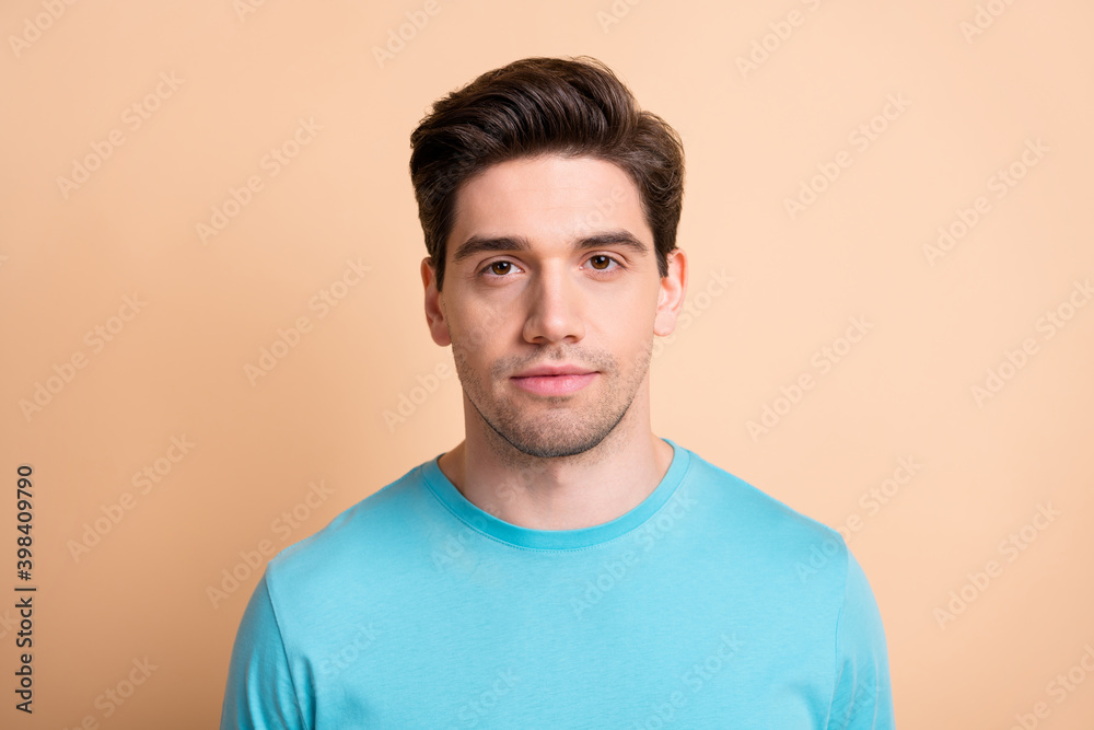 Close-up portrait of attractive content serious well-groomed guy isolated over beige pastel color background Close-up portrait of attractive content serious well-groomed guy isolated over beige pastel color background