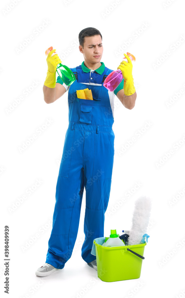 Young male janitor with cleaning supplies on white background Young male janitor with cleaning supplies on white background
