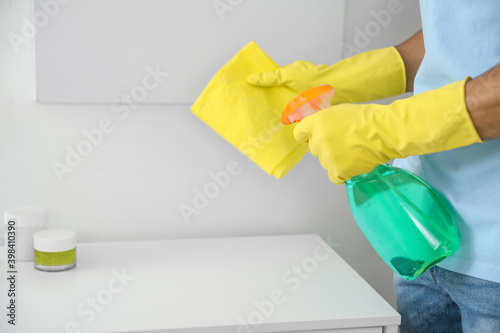 Young man cleaning his bathroom, closeup