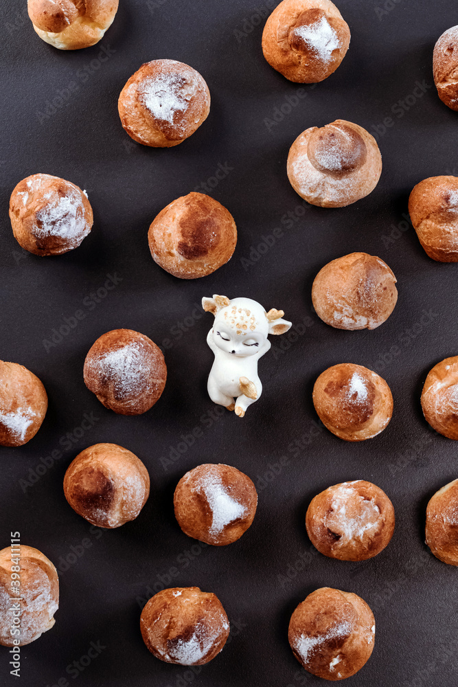 French profiteroles with cream. View from above. Many sweets on dark background.