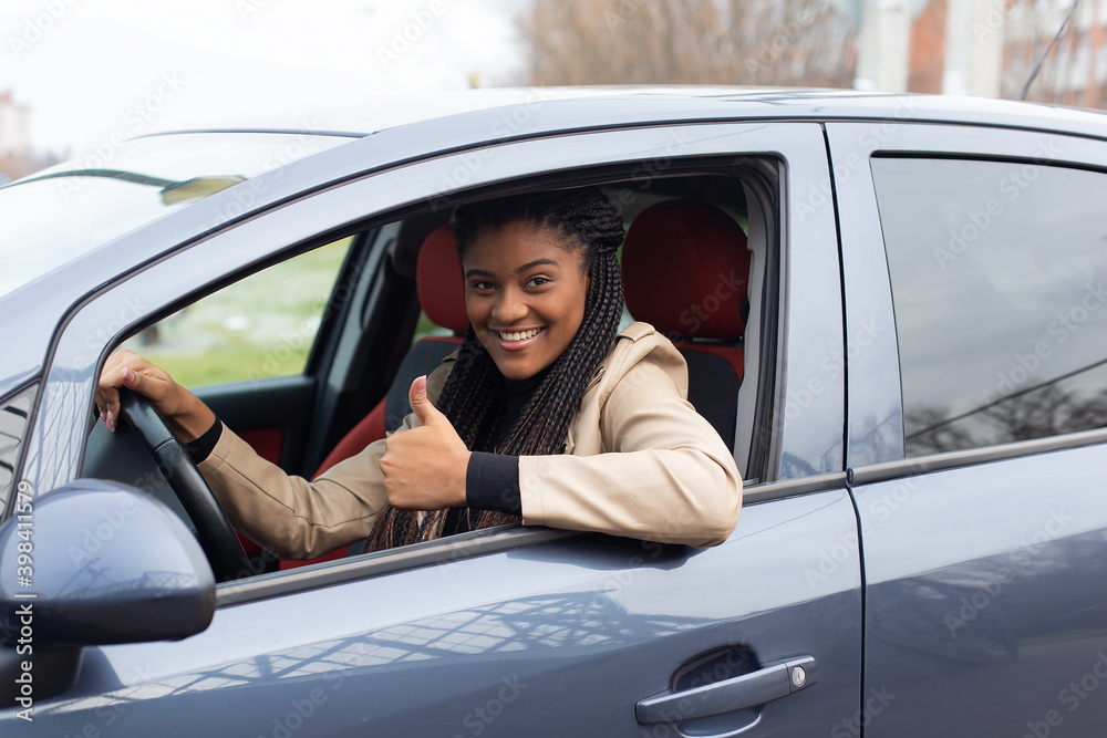Happy girl in a car driving, African American