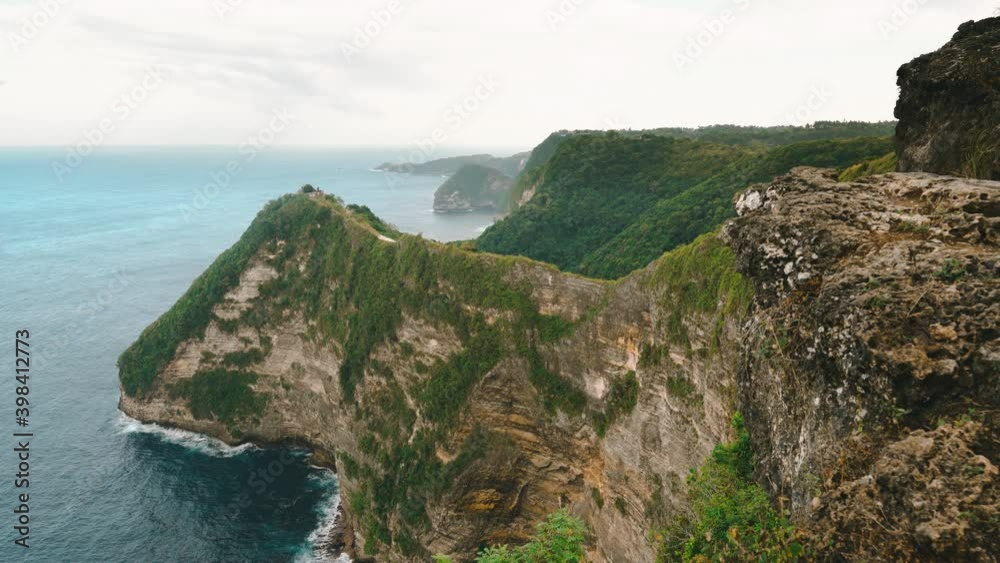 Nature landscape with mountain in sea and rocks. Amazing mountain cliff in the azure ocean water against the backdrop of beautiful tropical nature. Bali, Indonesia Nature landscape with mountain in sea and rocks. Amazing mountain cliff in the azure ocean water against the backdrop of beautiful tropical nature. Bali, Indonesia