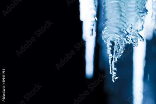 Icicles on black background, copy space, winter night background