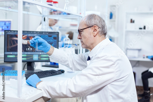 Senior doctor in biology working with dangerous substance contained in test tube. Viorolog researcher in professional lab working to discover medical treatment.