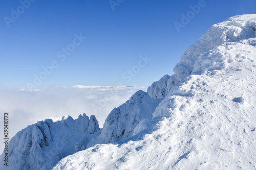 Winter mountain. Snowy peak high  above the clouds. Show and clouds on Dry Mountain  Serbia