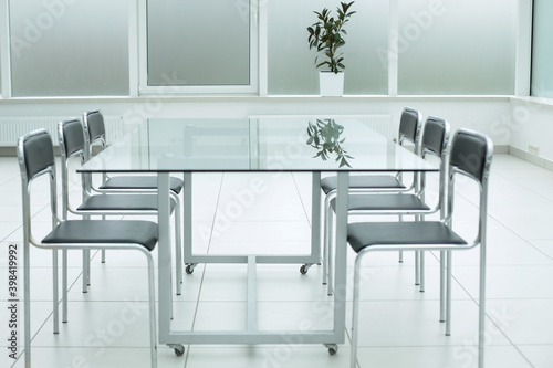 Black chairs glass table in office space © Qwenergy
