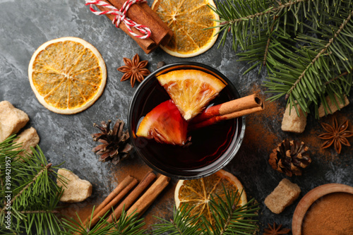 Glass of mulled wine and ingredients on black smokey background