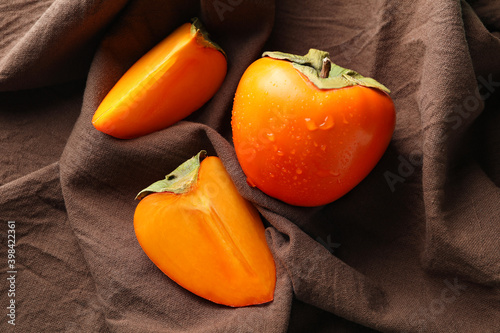 Brown kitchen towel with fresh ripe persimmon