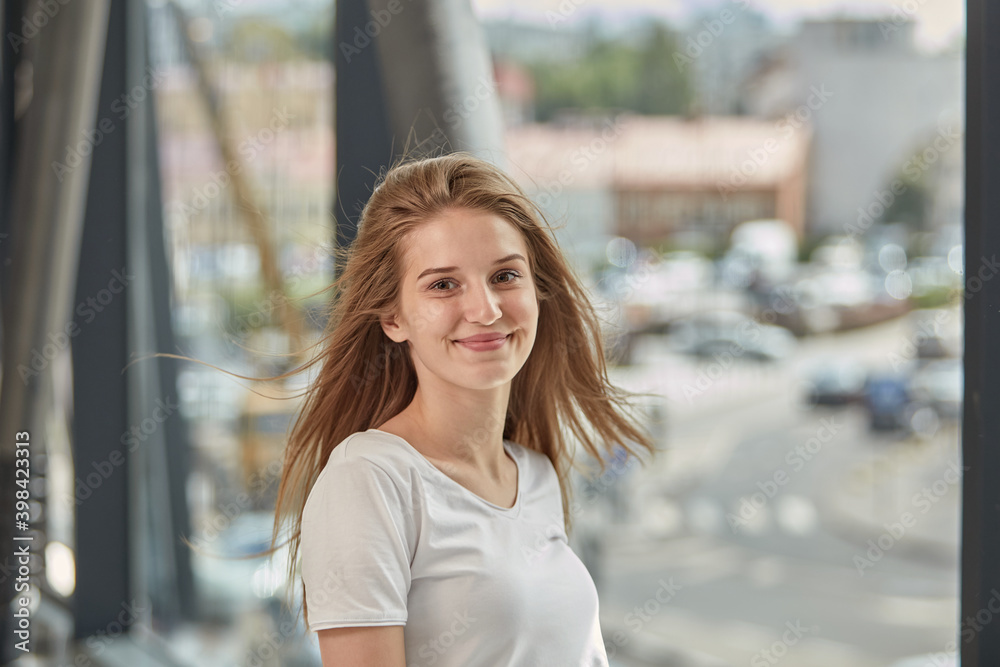 Happy young blonde woman with long hair flying in the wind. Against the background of iron pipes. Happy young blonde woman with long hair flying in the wind. Against the background of iron pipes.