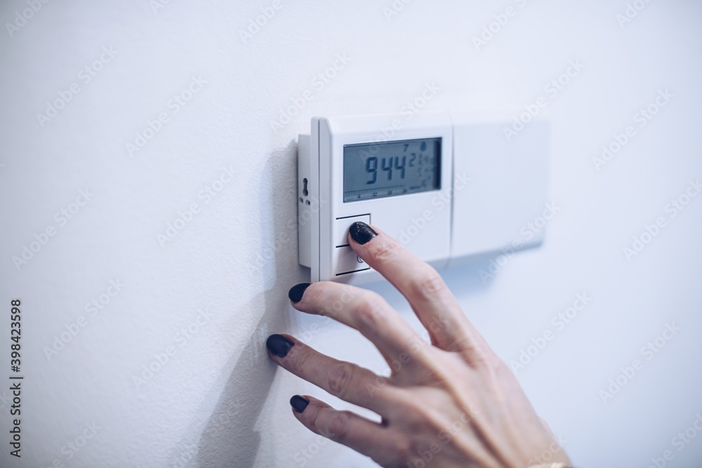 Regulating temperature on modern home heating control panel Regulating temperature on modern home heating control panel