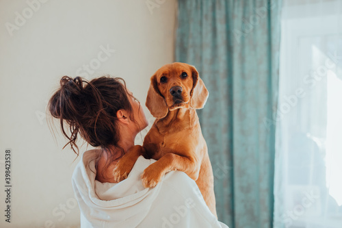 The woman of the house keeps a dog in her arms, the breed English Cocker Spaniel