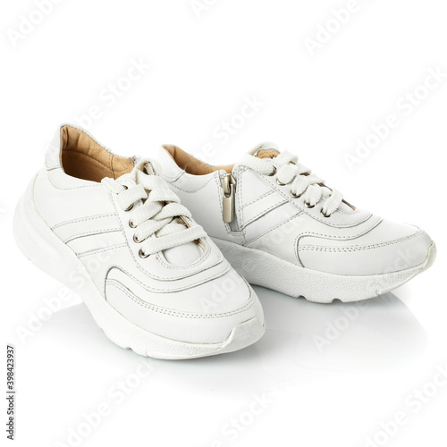 Pair of white baby sneakers isolated on white background with shadow.