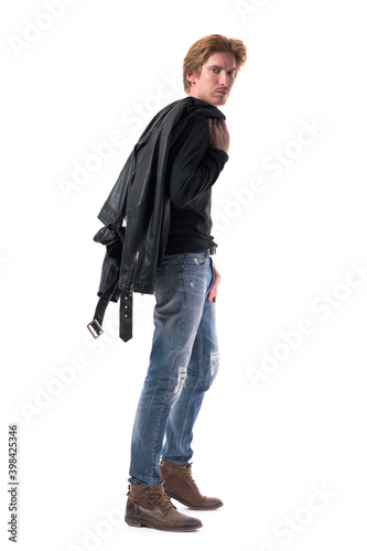 Side view of stylish walking redhead man carrying leather jacket over the shoulder. Full body length isolated on white background.  © sharplaninac