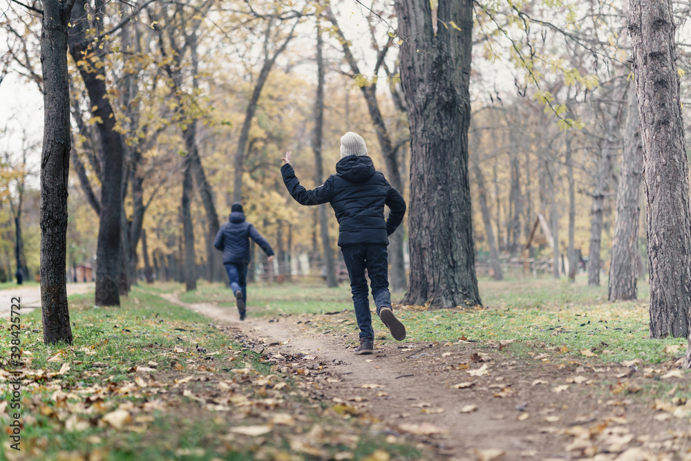 teen girl and boy running through the park and enjoys autumn, beautiful nature with yellow leaves teen girl and boy running through the park and enjoys autumn, beautiful nature with yellow leaves