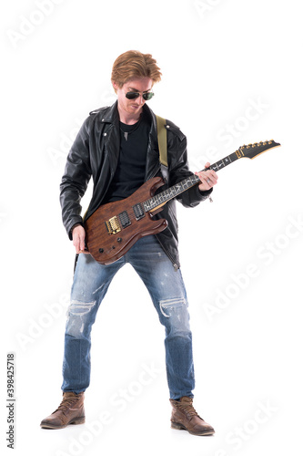 Stylish rock musician guitarist in leather jacket holding electric guitar prepare and get ready. Full body length isolated on white background. 