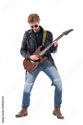 Macho young stylish man rock musician playing electric guitar solo looking down. Full body length isolated on white background. 