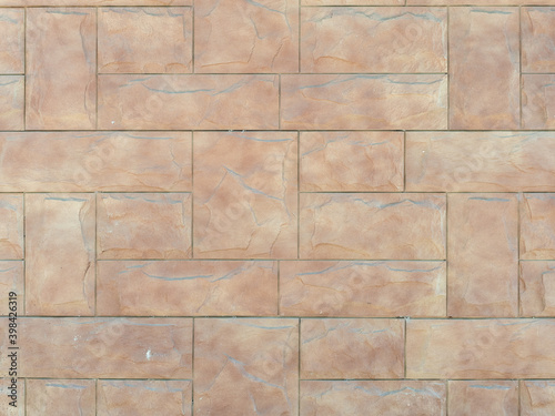 Beige wall with embossed rectangular tiles lined with pattern. Background texture