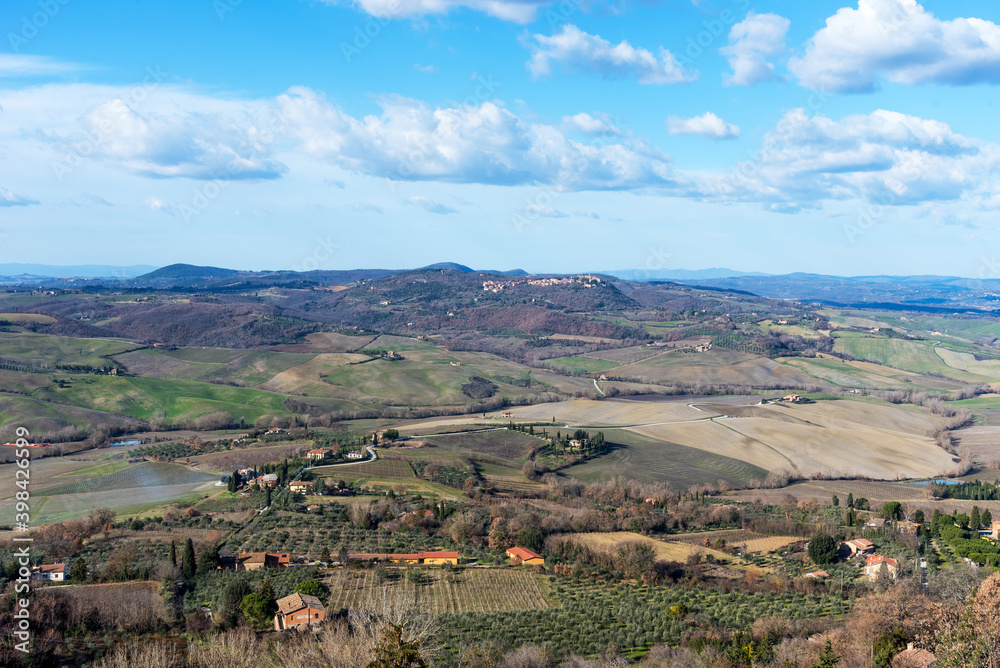 Obraz premium Picturesque winter landscape view of Tuscany with stone houses, colorful hills, fields and vineyards in Italy.