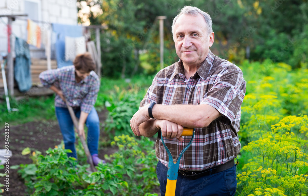 man farmer posing and digging in estate garden man farmer posing and digging in estate garden