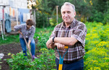man farmer posing and digging in estate garden