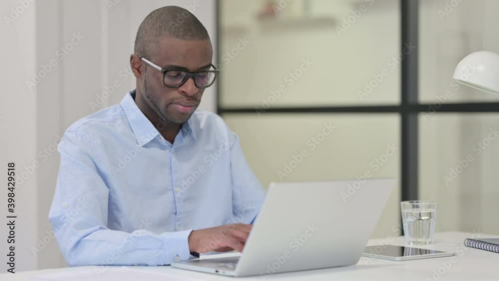Tired African Man Sleeping while Working on Laptop Tired African Man Sleeping while Working on Laptop