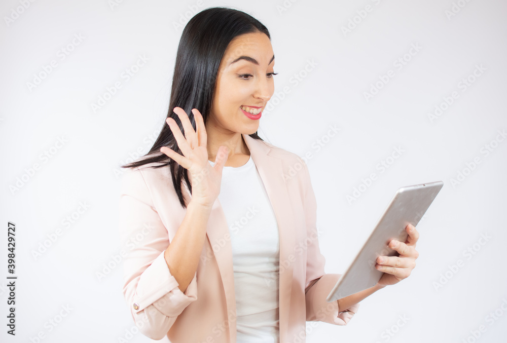Beautiful young business woman holding digital tablet surprised while standing over white background. Beautiful young business woman holding digital tablet surprised while standing over white background.